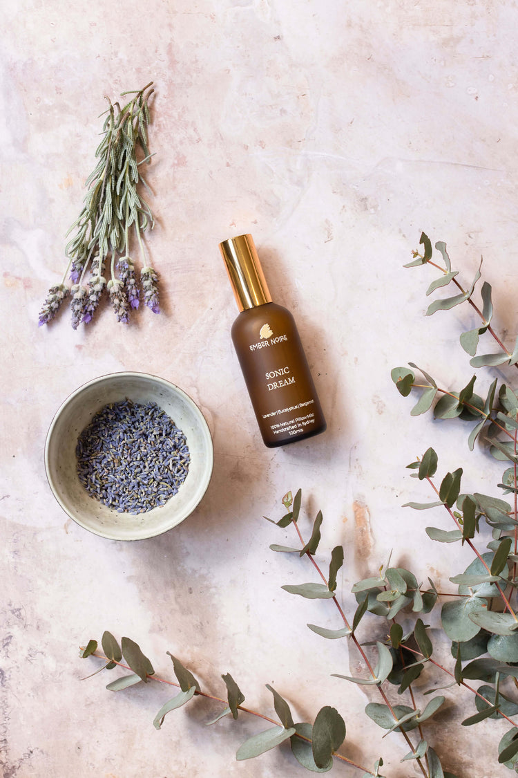 Close-up of lavender flowers bathed in soft purple and pink light, creating a calming, serene atmosphere. Perfectly captures the soothing essence of the Pillow Spray collection, designed to enhance relaxation and promote restful sleep.