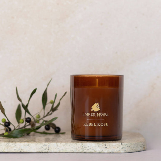 Rebel Rose candle with greenery on marble tile 