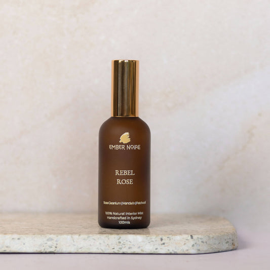 Rebel Rose Natural interior mist in Amber bottle on marble tile 