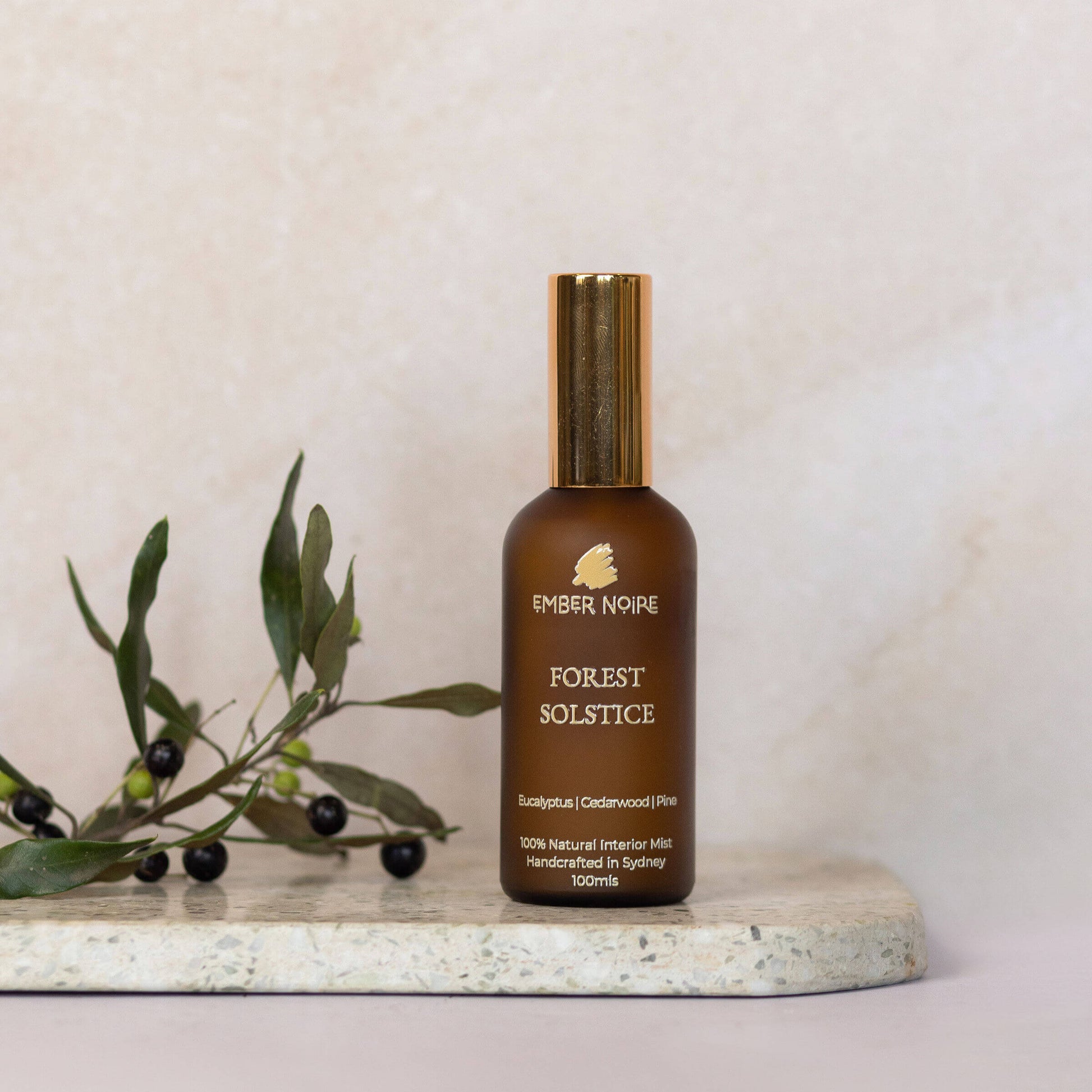 Forest Solstice Natural interior mist in Amber bottle on marble tile 