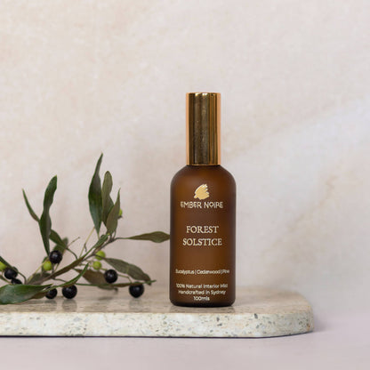 Forest Solstice Natural interior mist in Amber bottle on marble tile 