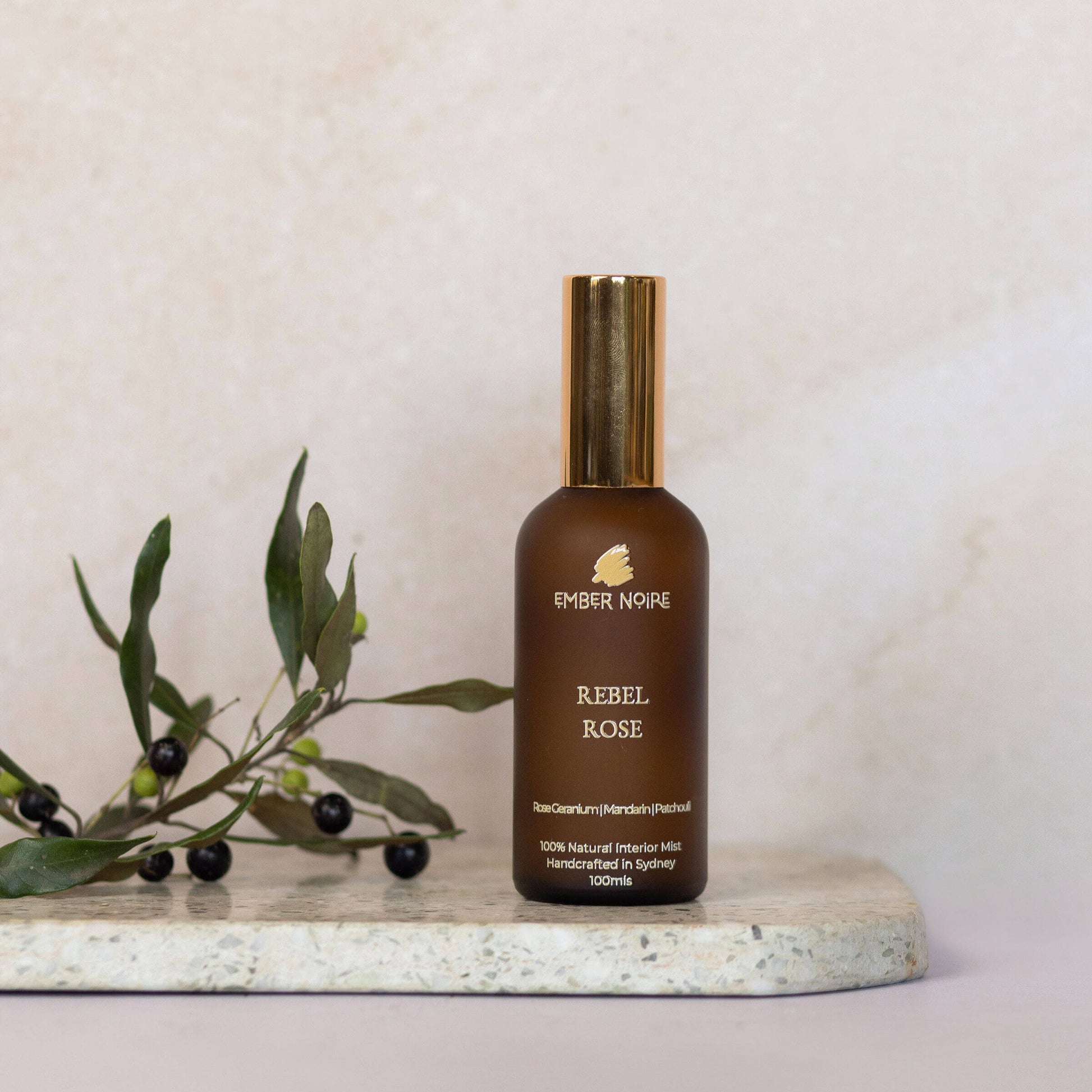 Rebel Rose Natural interior mist in Amber bottle on marble tile 