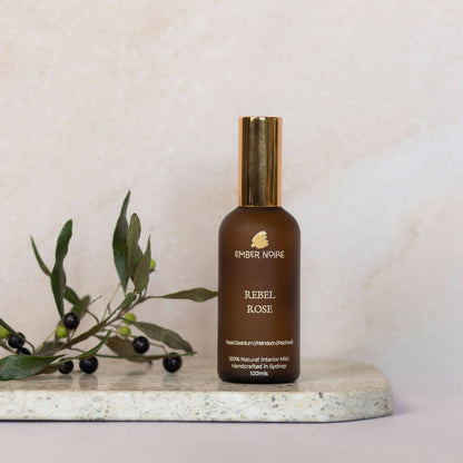 Rebel Rose Natural interior mist in Amber bottle on marble tile 