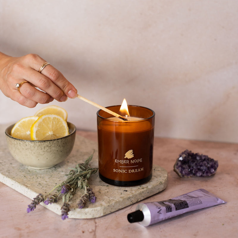 Candle surrounded by ingredients being light. 