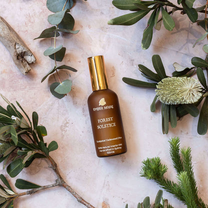 Forest Solstice Natural interior mist in Amber bottle flatlay with greenery