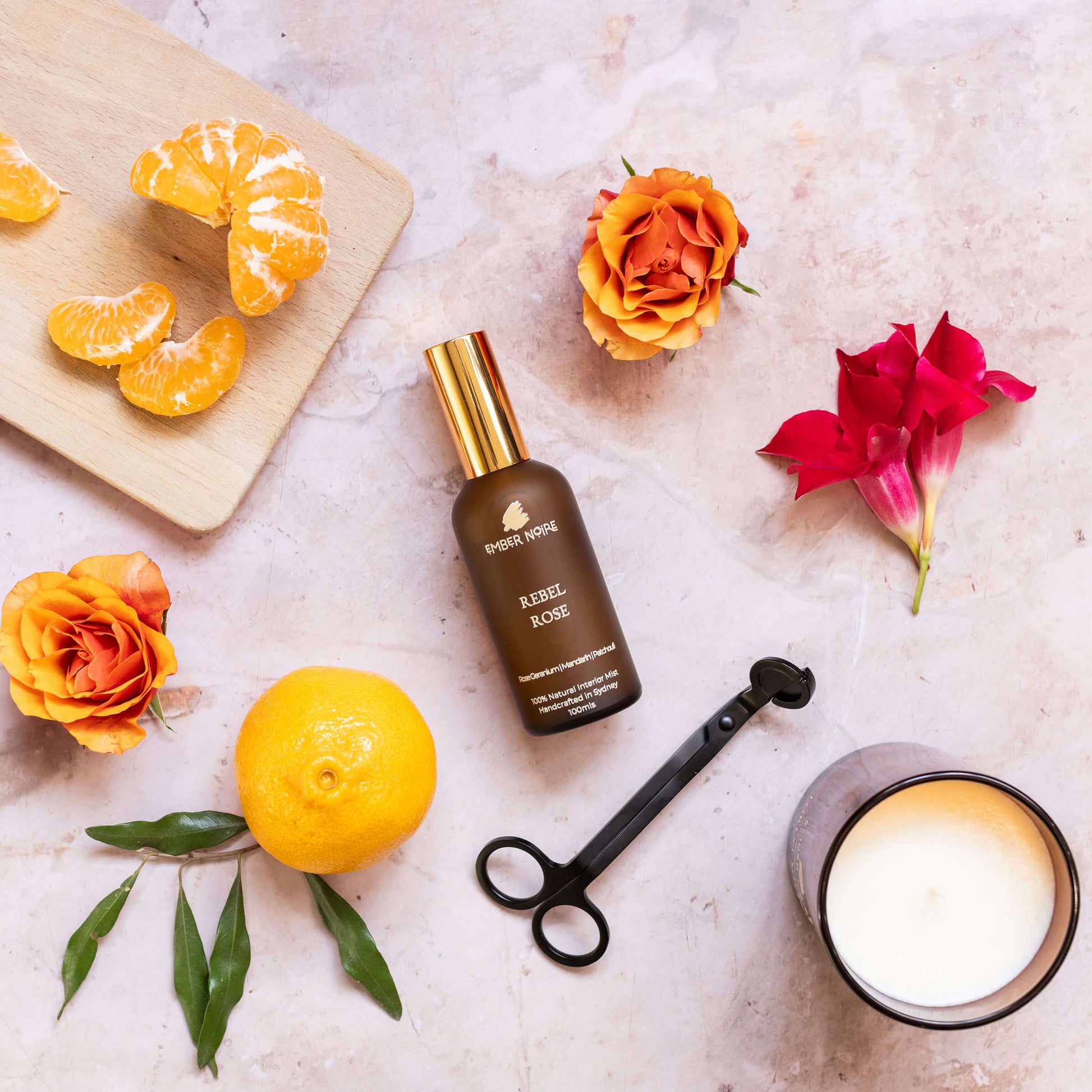 Natural interior mist in Amber bottle flatlay with rose, madarin, candle 