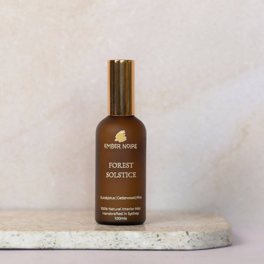 Forest Solstice Natural interior mist in Amber bottle on marble tile 